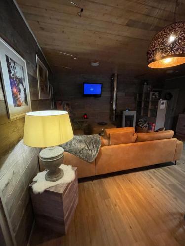 uma sala de estar com um sofá e uma mesa com um candeeiro em B&B A L'aise em Durbuy
