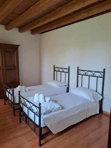 two beds in a room with wooden floors at Appartamento Agli Alberoni in Caorle