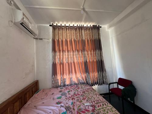 a small bedroom with a bed and a window at Ravan Holiday Inn in Trincomalee