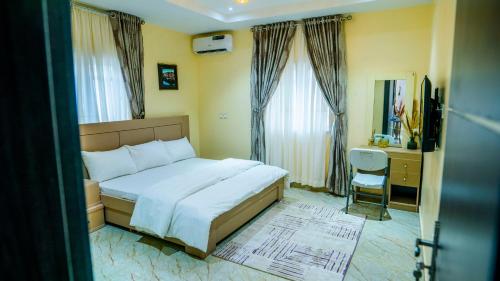 Gwarinpaにある2bedroom Masters Apartmentのベッド、デスク、窓が備わるホテルルームです。