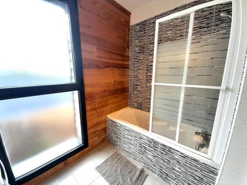 ein Badezimmer mit einem Fenster und einer Badewanne neben in der Unterkunft Sublime villa 9 pers- 5chb-pisicne-wifi in Le Poinçonnet