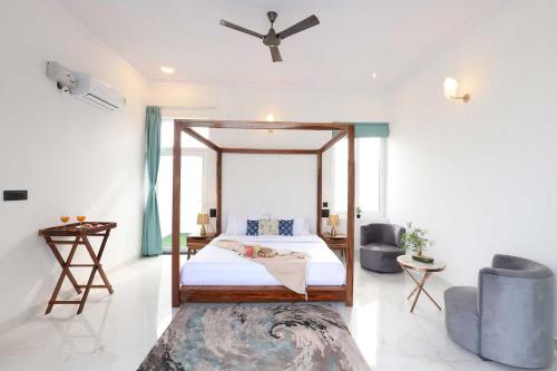 Schlafzimmer mit einem Bett und einem Deckenventilator in der Unterkunft Edo Mansion By The Party Citadel - Luxury villa with pool, garden area, massive garden etc. in Jaipur