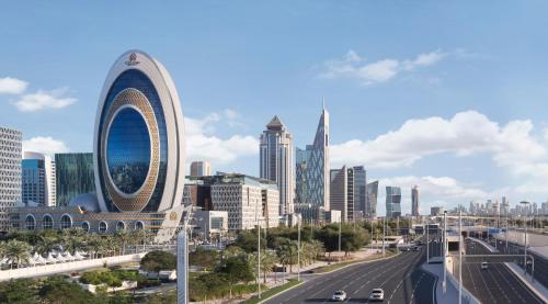 Blick auf eine Stadt mit Autobahn und Gebäuden in der Unterkunft Velero Hotel Doha Lusail in Doha
