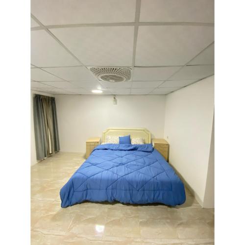 um quarto com uma cama com um edredão azul em nizwa a partment em Wāsiţ
