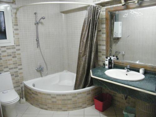 uma casa de banho com uma banheira, um lavatório e um WC. em Mohandeseen apartment المهندسين عائلات no Cairo