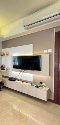 un salon avec une grande télévision murale à écran plat dans l'établissement Belle’s WMR Apartment, à Jakarta