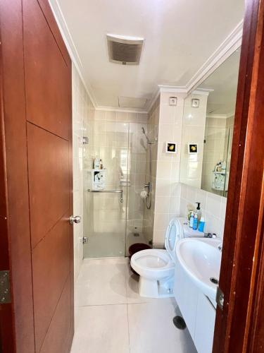 La salle de bains est pourvue de toilettes, d'un lavabo et d'une douche. dans l'établissement Belle’s WMR Apartment, à Jakarta