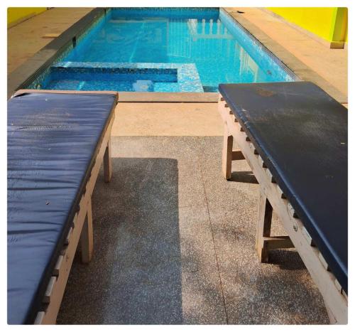 a pool with a bench next to a swimming pool at Palash Villa in Aguada