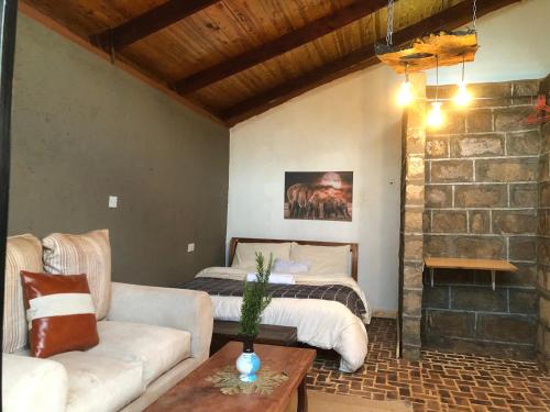 sala de estar con sofá y cama en Mashambani Cottages en Nyahururu