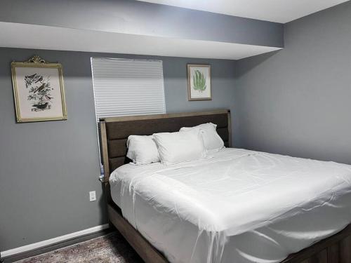 1 dormitorio con 1 cama grande con sábanas blancas en Urban 3bedroom Luxury beside Newark airport/Downtown newark, en Newark