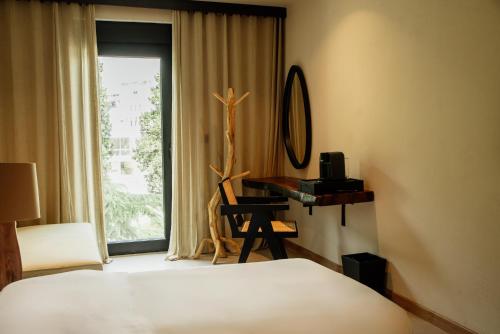 a bedroom with a bed and a desk and a window at Hotel 1920 in Podgorica