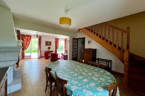 une salle à manger avec une table et des chaises et un escalier dans l'établissement Maison familiale 10 p, à pied des plages de Port-Blanc, à Penvénan