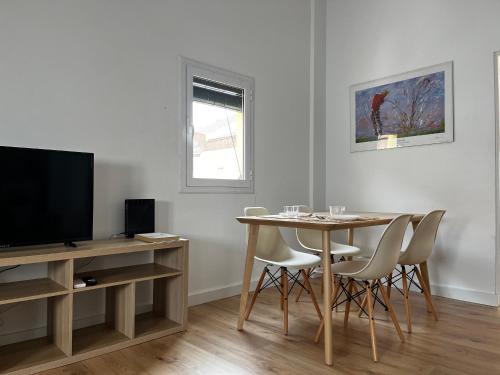 uma sala de estar com uma mesa de jantar e uma televisão em Mon Residence Sant Jeroni em Manresa