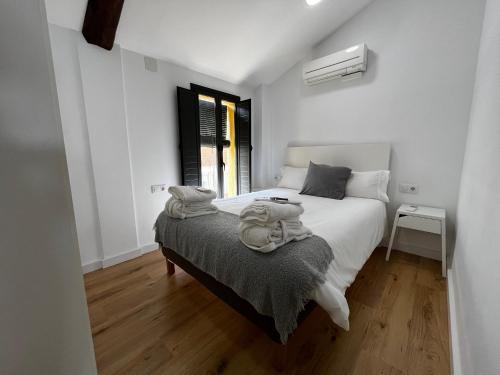 - une chambre avec un lit et des serviettes dans l'établissement Mon Residence Sant Jeroni, à Manresa