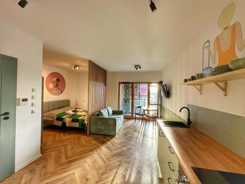 ein Zimmer mit einer Küche und ein Schlafzimmer mit einem Bett in der Unterkunft 3 Waves Apartment Gdansk STARÓWKA- GYM, SAUNA, KidsPlay, PARKING in Danzig