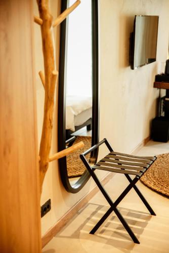 a chair in front of a mirror in a room at Hotel 1920 in Podgorica