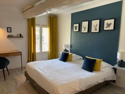 - une chambre avec un grand lit et un mur bleu dans l'établissement Logis Hôtel Restaurant La Sommellerie, à Châteauneuf-du-Pape