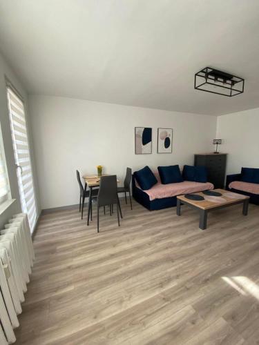 ein Wohnzimmer mit einem Sofa und einem Tisch in der Unterkunft Apartament pod Kotwicą in Nowa Sól
