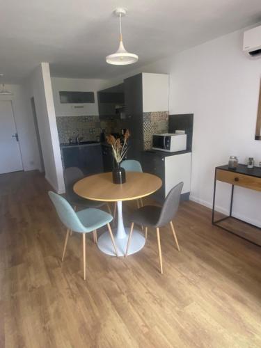 a kitchen with a table and two chairs and a table at Appartement proche du départ du GR20 in Calenzana