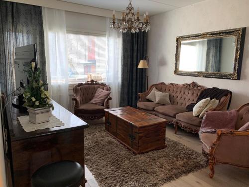 a living room with couches and a table and a mirror at 2 bedroom apartment, Turku in Turku
