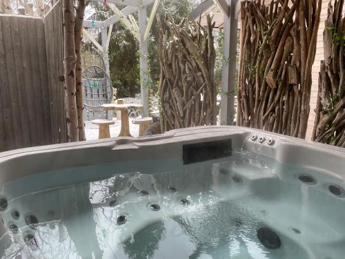 a jacuzzi tub in a yard with a fence at B&B A L'aise in Durbuy