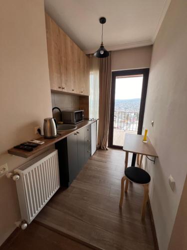 una pequeña cocina con mesa y ventana en Luca's Apartment in old tbilisi, en Tiflis