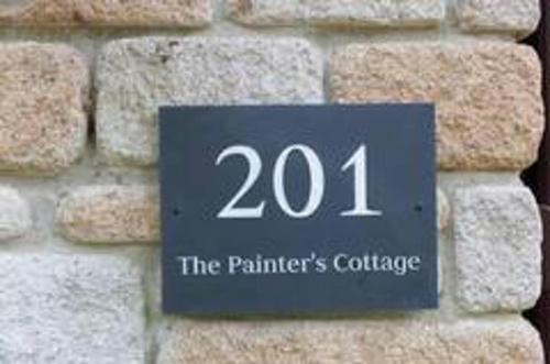 a sign on a brick wall with the number at Painters Cottage 2-Bed Chalet nr St Ives & Hayle in St Ives