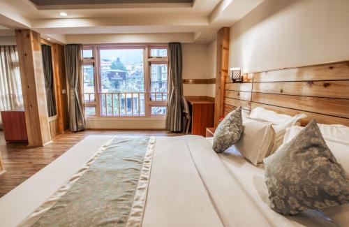 a large bed in a room with a large window at Gangtok Prime Hotel & Spa in Gangtok