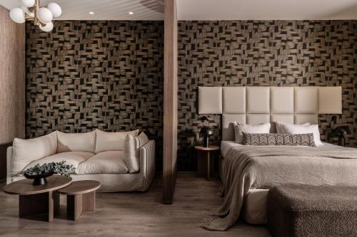 - une chambre avec un lit et un canapé dans l'établissement Elegance Luxury Executive Suites - Adults Only, à Tragaki