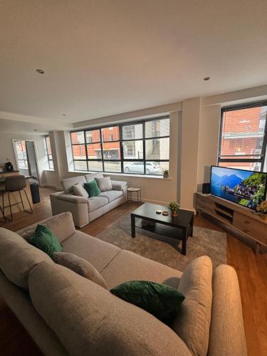 a living room with a couch and a flat screen tv at 2 Bedroom, 2 Bathroom Flat in Nottingham City Centre with FREE Parking in Nottingham