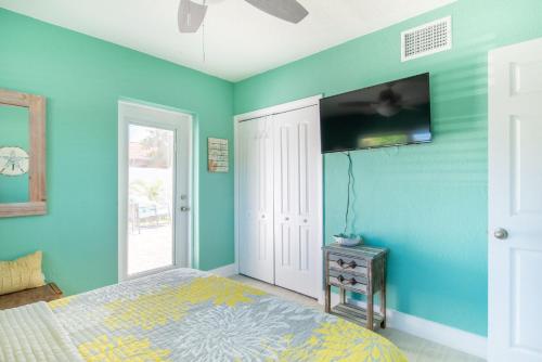 a bedroom with a bed and a tv on the wall at Sunny Delight II in Cape Canaveral