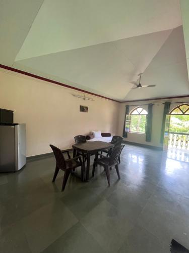 a dining room with a table and chairs and a refrigerator at Green valley jungle resort in Pernem
