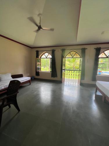 a large room with two beds and two windows at Green valley jungle resort in Pernem