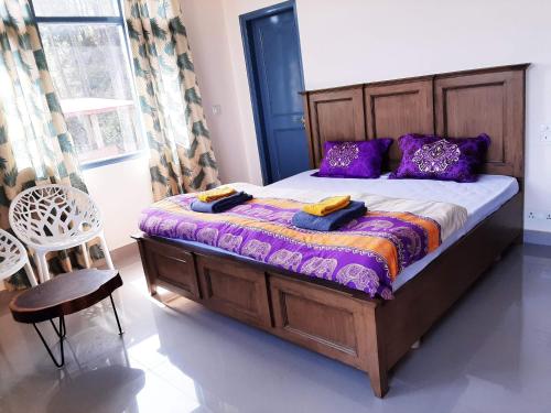 - une chambre avec un grand lit et des oreillers violets dans l'établissement Vista Solan, à Solan
