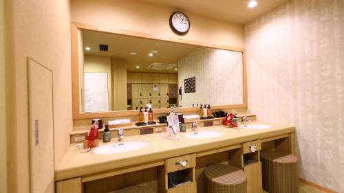 uma casa de banho com 2 lavatórios e um espelho grande em Onyado Nono Sendai Natural Hot Spring em Sendai