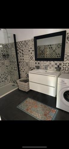a bathroom with a sink and a washing machine at Appartement proche du départ du GR20 in Calenzana