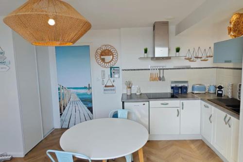 - une cuisine avec des placards blancs, une table, une table et des chaises dans l'établissement BERCK Beach Attitude 160 QUEEN SIZE très confort - 3min de la plage, à Berck-sur-Mer