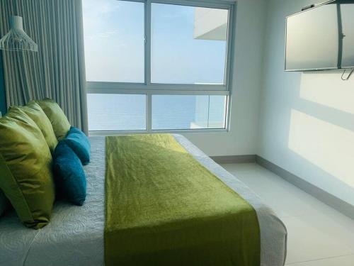 a bed in a room with a large window at Apartament Bocagrande Palmetto Beach Front 3204 in Cartagena de Indias