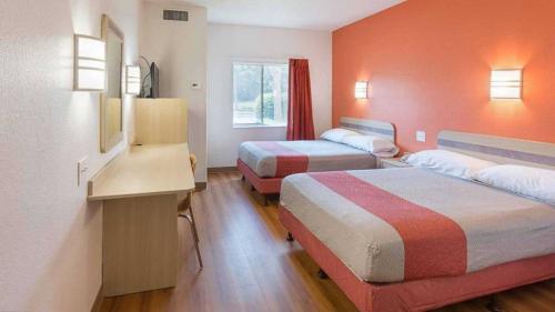 ein Hotelzimmer mit 2 Betten und einem Schreibtisch in der Unterkunft Motel 6 in Columbia