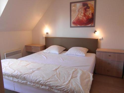 um quarto com uma cama branca e duas mesas de cabeceira em Cezanne app 0501 em Nieuwpoort