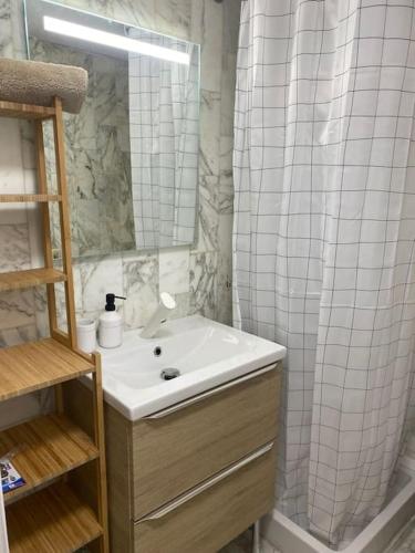une salle de bain avec un lavabo et un rideau de douche dans l'établissement Grand Studio dans Résidence avec Piscine, à Hyères