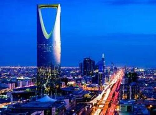 uma vista para uma cidade à noite com um edifício alto em Talya Home em Riyadh