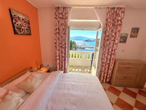 um quarto com uma cama e uma grande janela em Apartments Okuka em Tivat