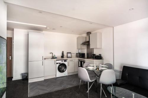 cocina con lavadora, mesa y sillas en Smart 1 Bed Central Preston Apartment en Preston
