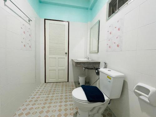 a white bathroom with a toilet and a sink at NUN GUEST HOUSE in Ban Bo Han