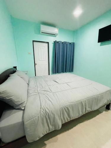 a bedroom with a large bed in a blue room at NUN GUEST HOUSE in Ban Bo Han