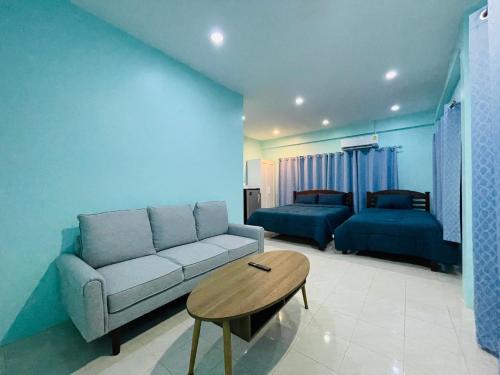 a living room with a couch and a table at NUN GUEST HOUSE in Ban Bo Han