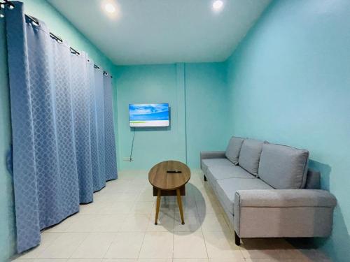 a living room with a couch and a table at NUN GUEST HOUSE in Ban Bo Han