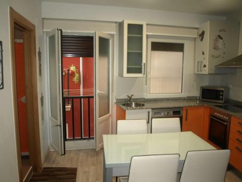 a kitchen with a white table and white chairs at La Casita de Diana Laredo, Casco Antiguo, playa cercana, parking privado a 300m, Petfriendly in Laredo