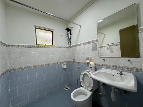 een badkamer met een toilet, een wastafel en een spiegel bij A’famosa Villa D’amour in Melaka